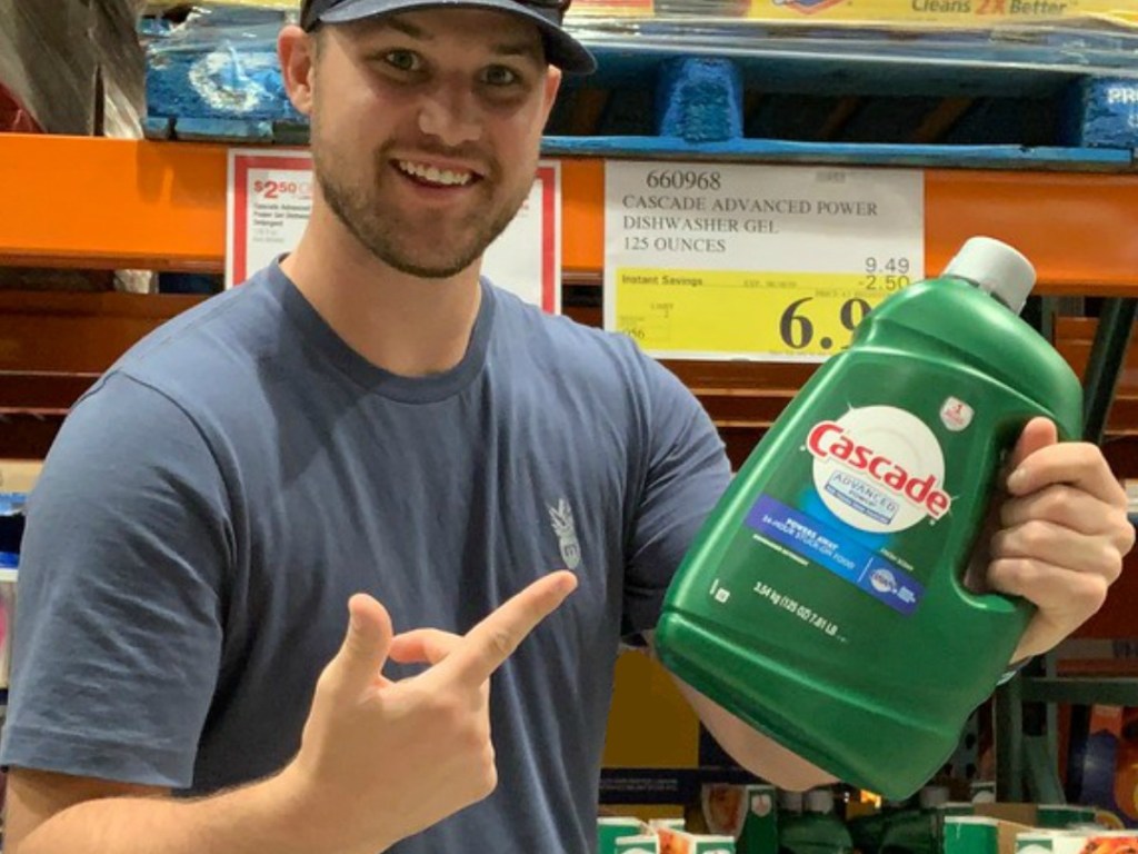 Man holding and pointing at Cascade Liquid Dishwasher Gel 125 Oz bottle in Costco