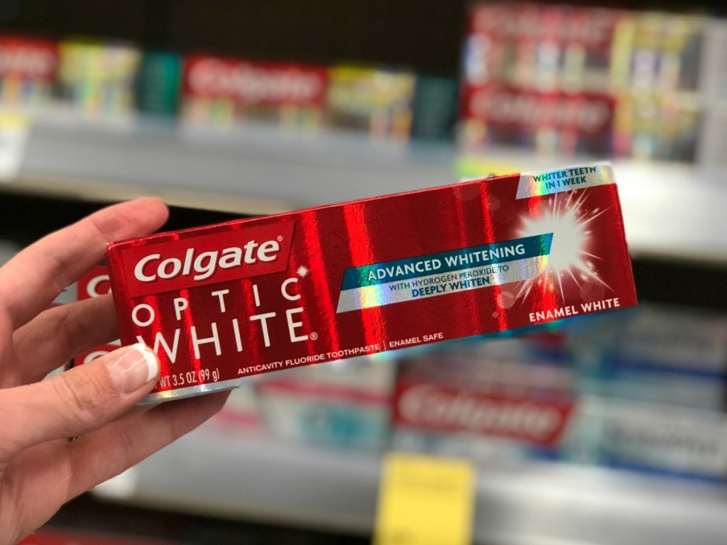 woman hand holding Colgate Optic White Toothpaste