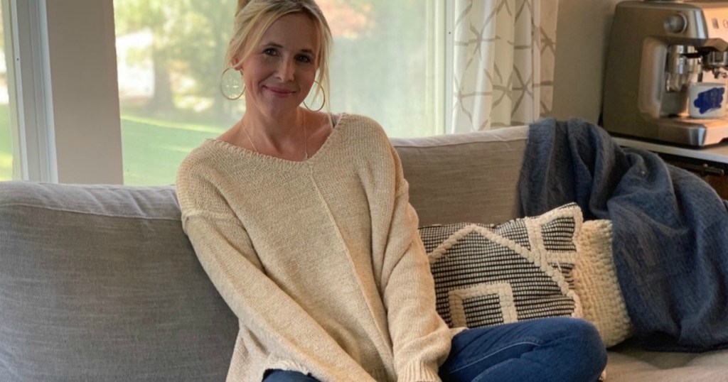 woman wearing sweater sitting on couch