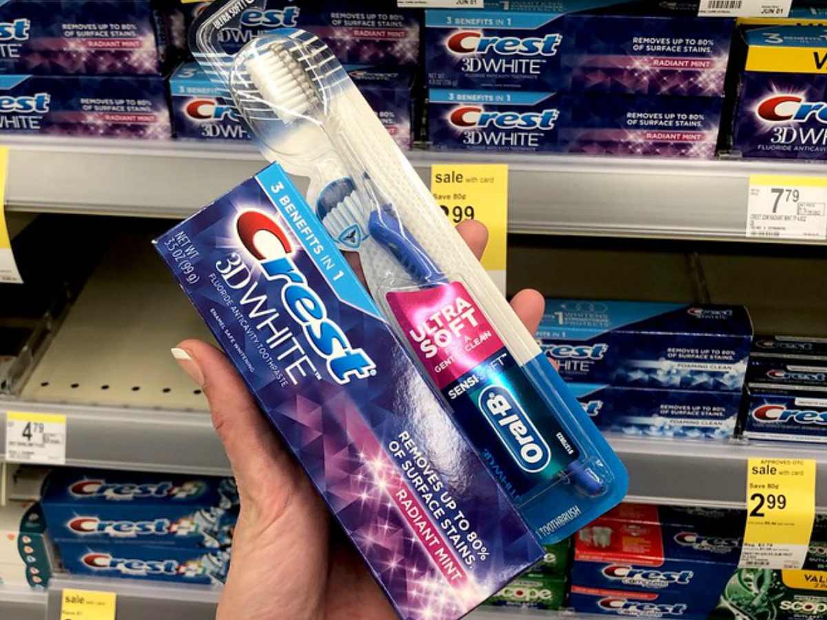 hand holding Crest toothpaste and Oral-B toothbrush in Walgreens store