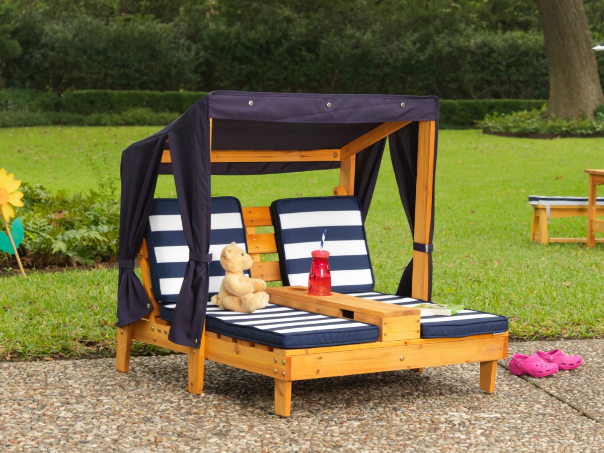 kids double chaise lounger with navy and white striped cushions outside on patio