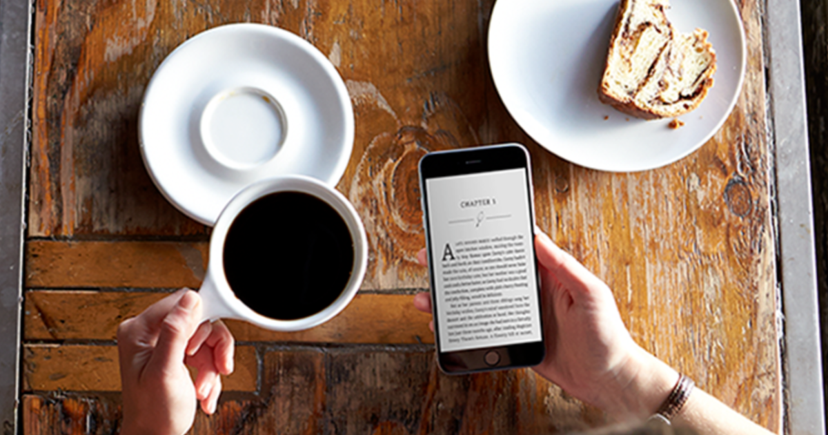 person reading kindle while drinking coffee
