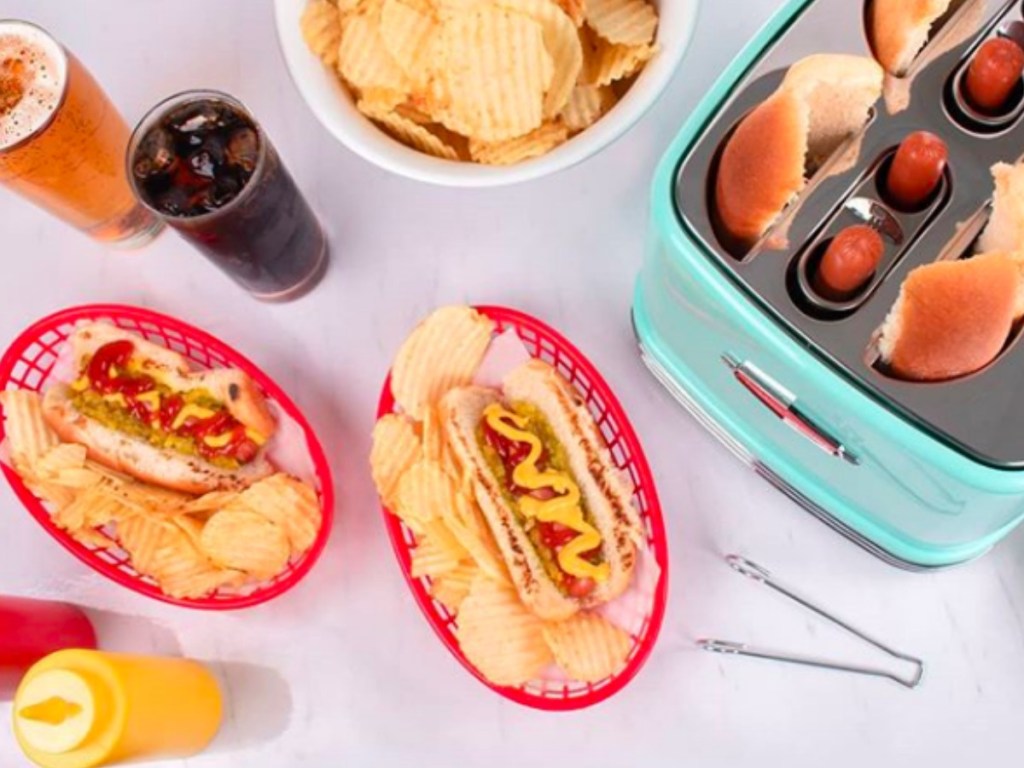 Nostalgia Electrics 2-Slot Hot Dog Toaster with hot dogs, soda and condiments