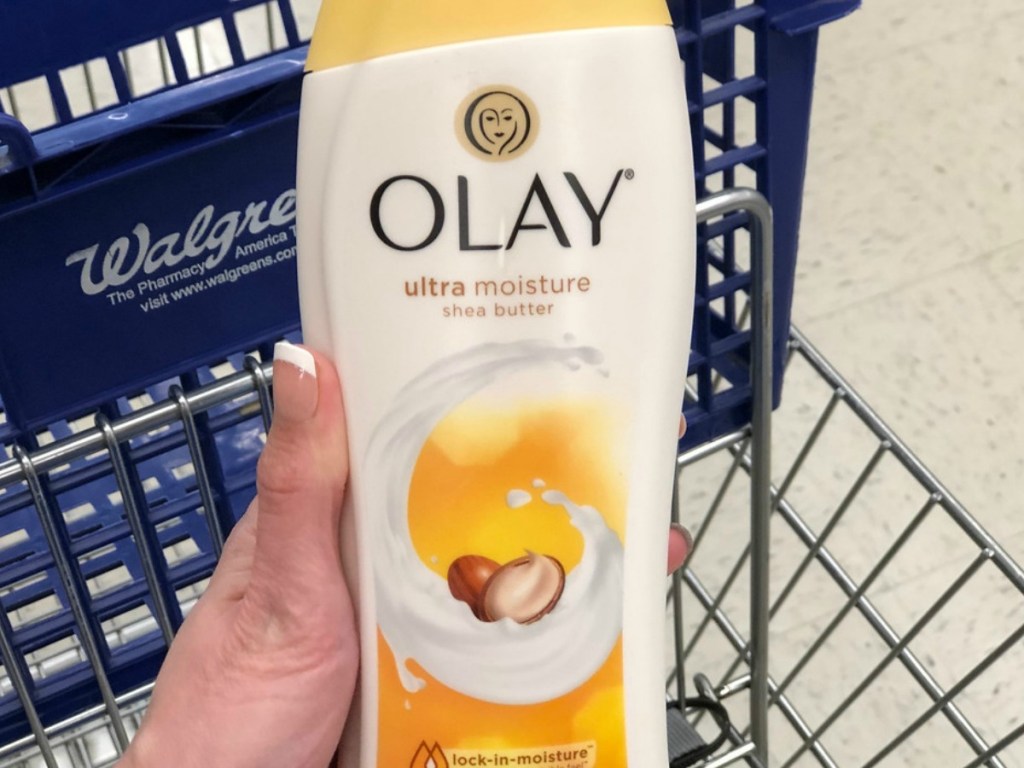 Woman's hand holding Olay Body Wash with Walgreens shopping basket in background