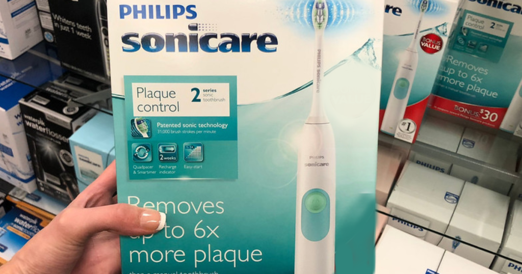 Woman's hand holding Philips Sonicare Series 2 Plaque Control Rechargeable Toothbrush