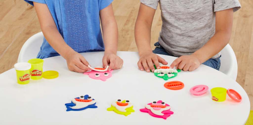 kids using cookie cutters to play at table