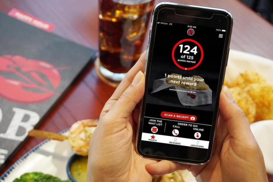 man holding a phone with membership points featured on it