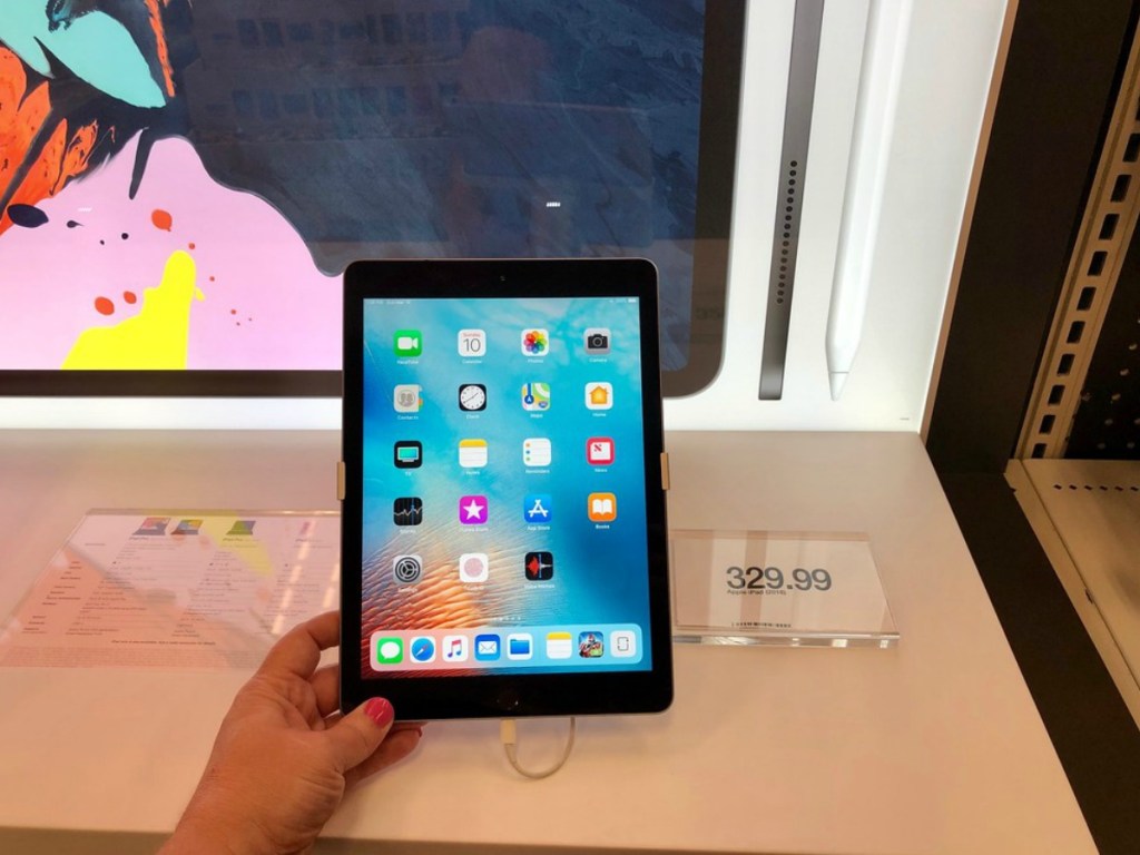 black ipad with hand holding it in apple store