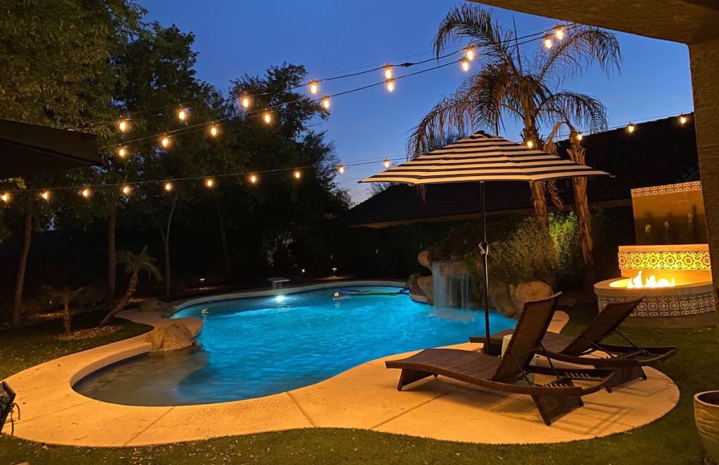 backyard with pool fire pit and string lights