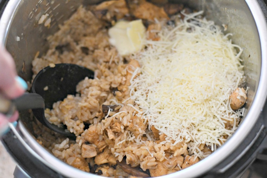 fluffing risotto with parmesan cheese and butter