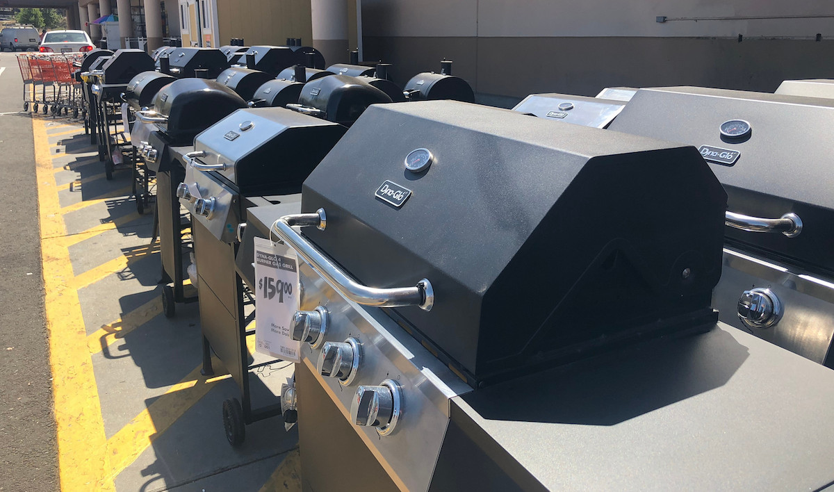 various types of outdoor grills lined up outside on pavement in front of home depot store- best time to shop annual sales cycles
