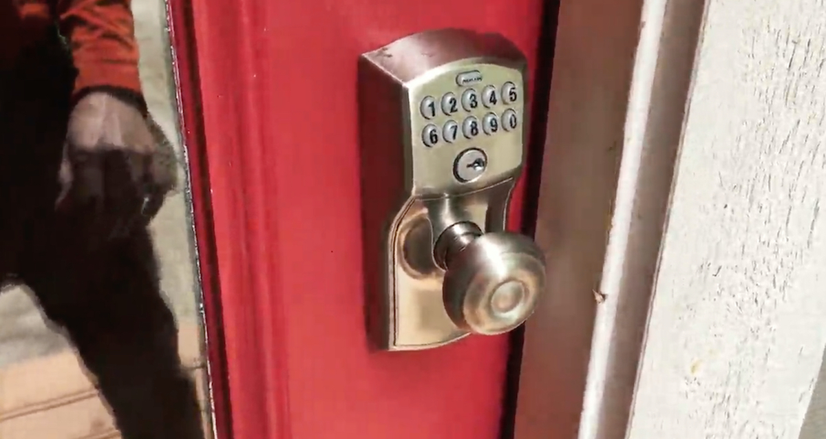 silver doorknob with keyless door lock and keypad on red door