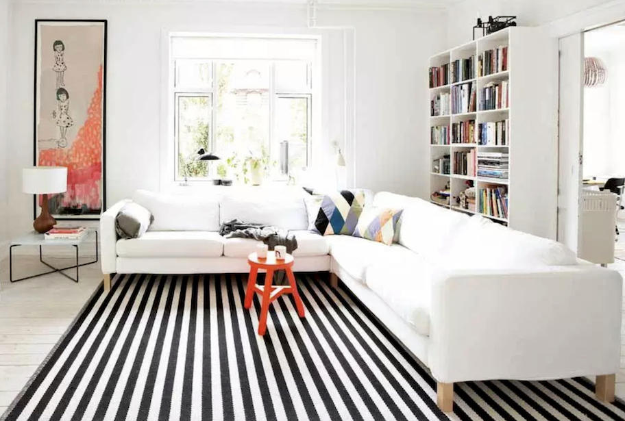 living room with black and white stripe rug and sectional l-shape couch