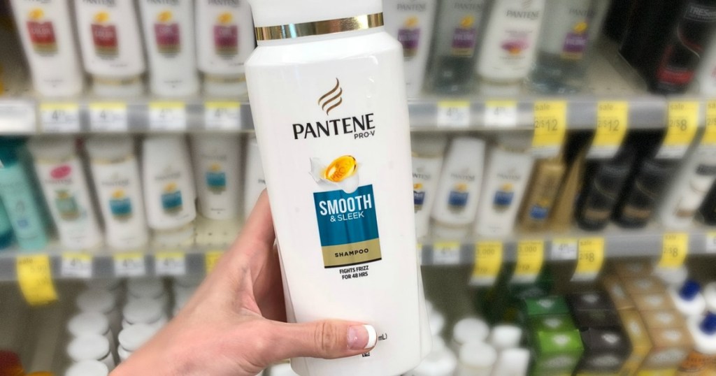 pantene smooth & sleek shampoo being held in woman's hand in store