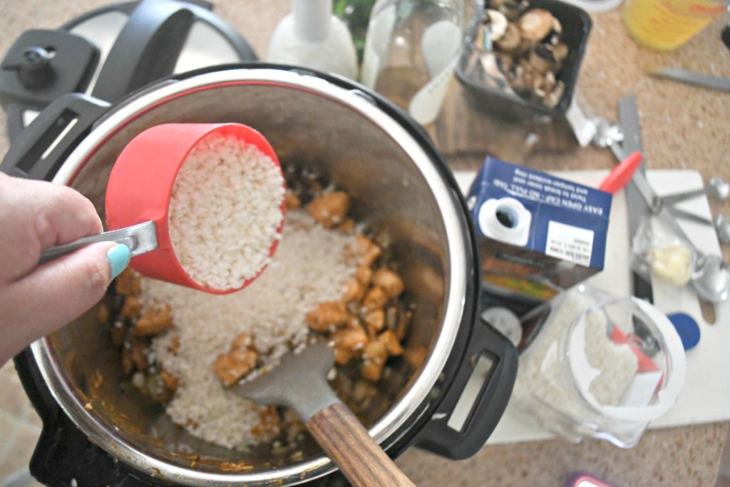 pouring rice in instant pot for chicken risotto dinner