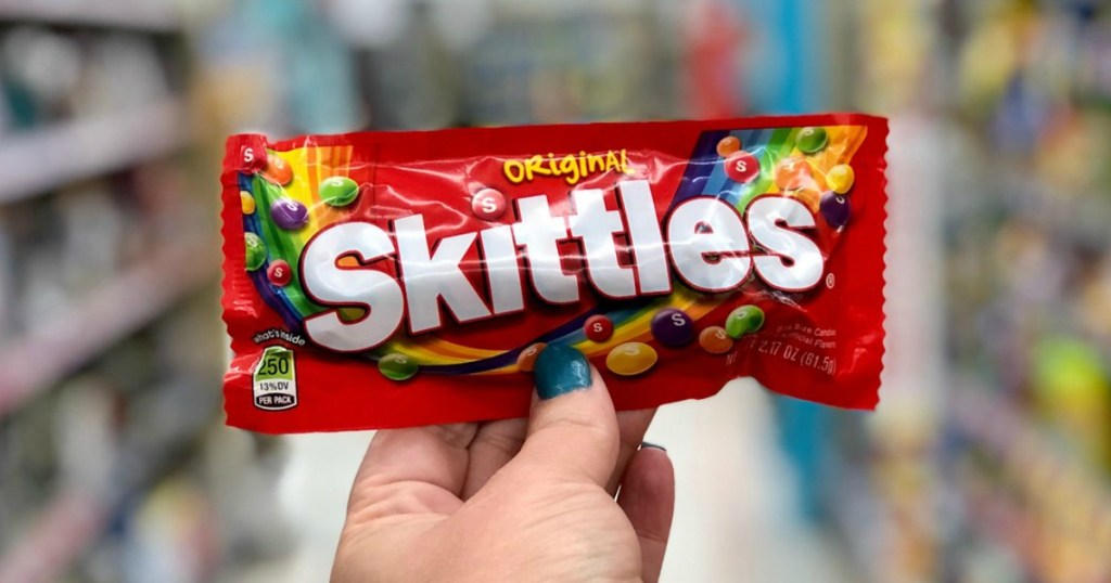 hand holding skittles bag with blurred background