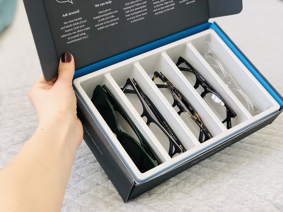 hand holding a box of warby parker glasses