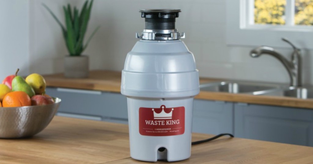 garbage disposal sitting on kitchen counter with waste king and logo written on side of disposal