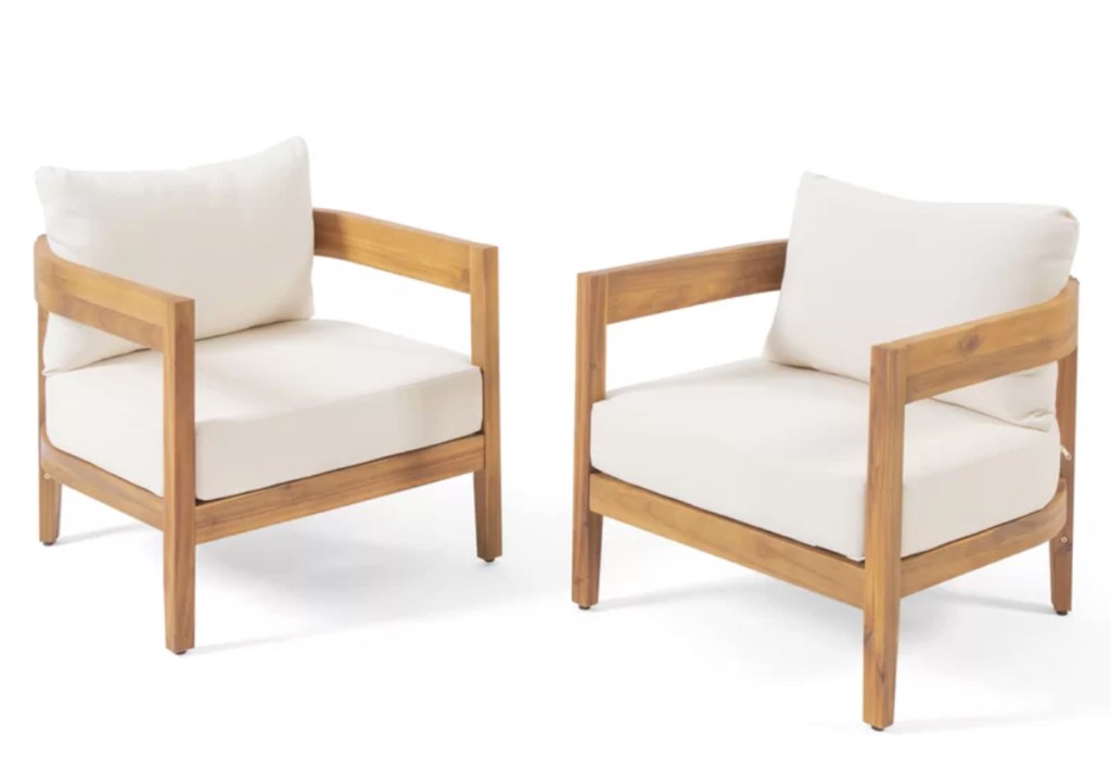 two wood patio chairs with white cushions