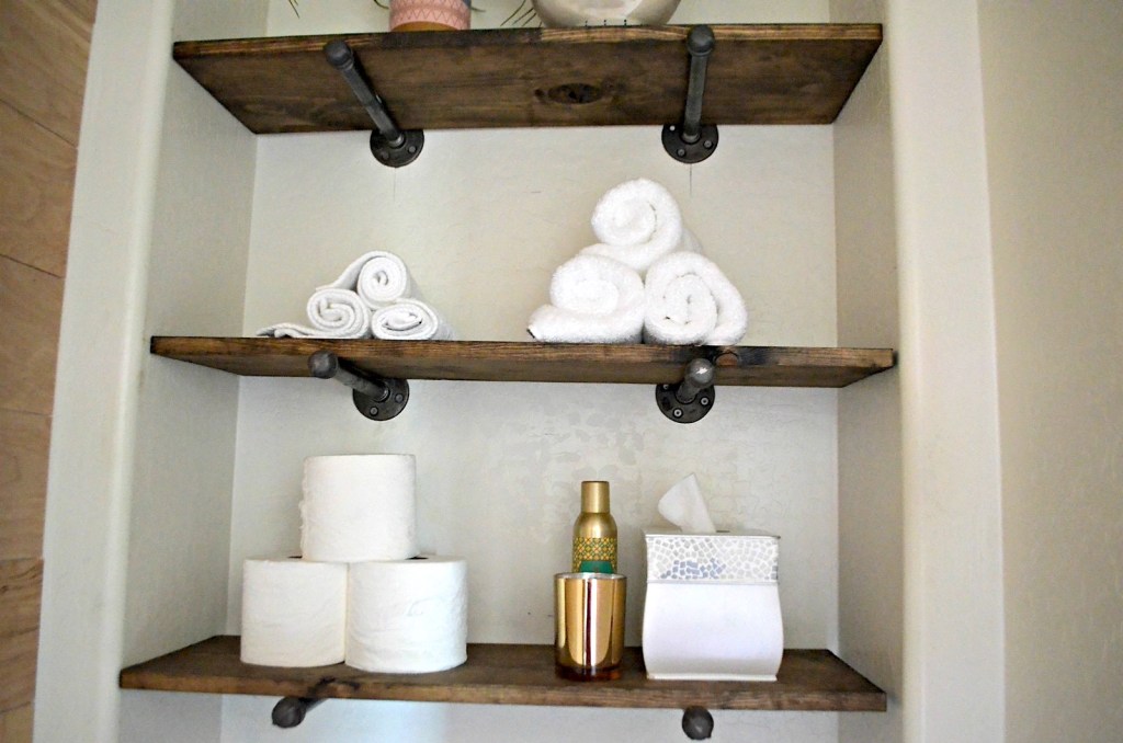 industrial pipe shelving with towels and toilet paper 