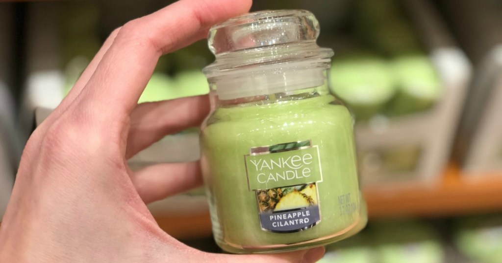 hand holding yankee candle small jar candle