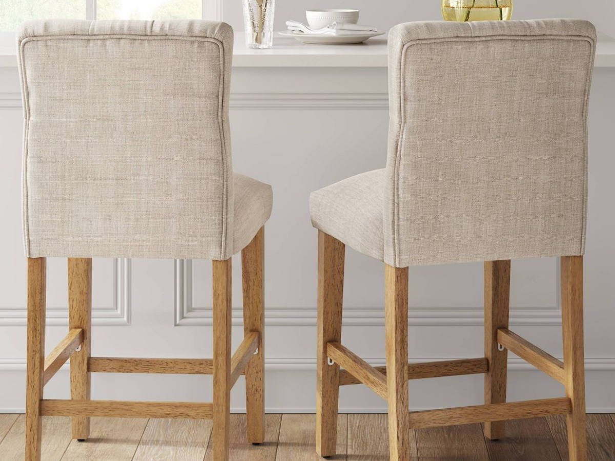 two counter stools with linen covers and wooden legs