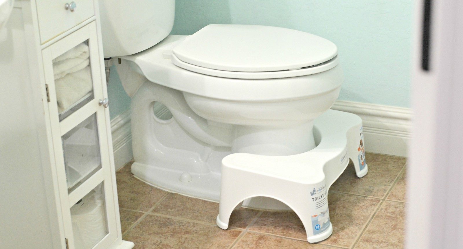 a bethroom toilet with footstool