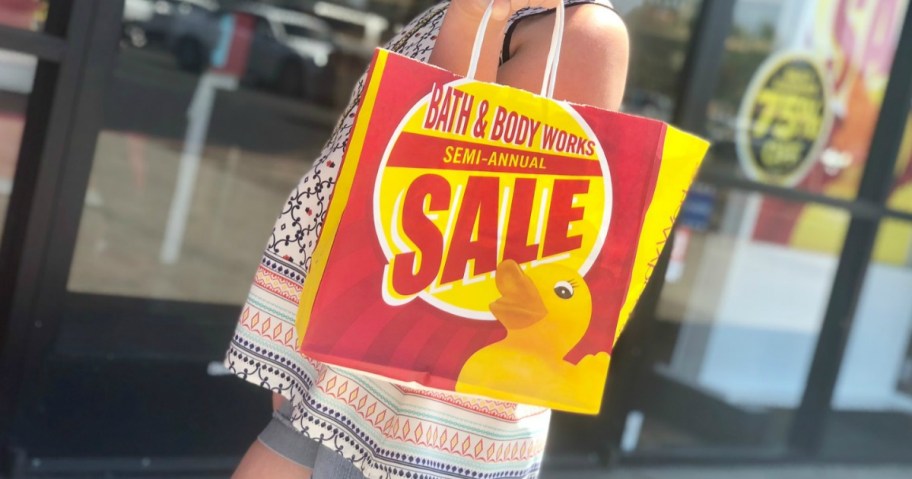 girl carrying bath $ body works semiannual sale bag