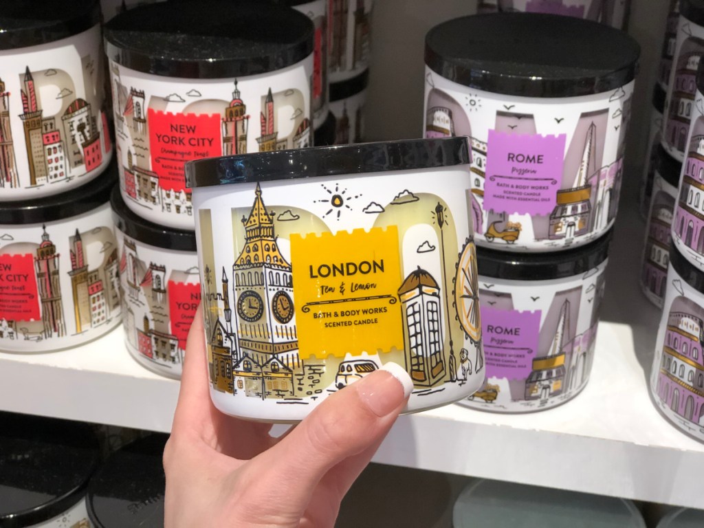 Bath & Body Works London Tea & Lemon 3 wick candle held in hand in store with various 3 wick candles in the background