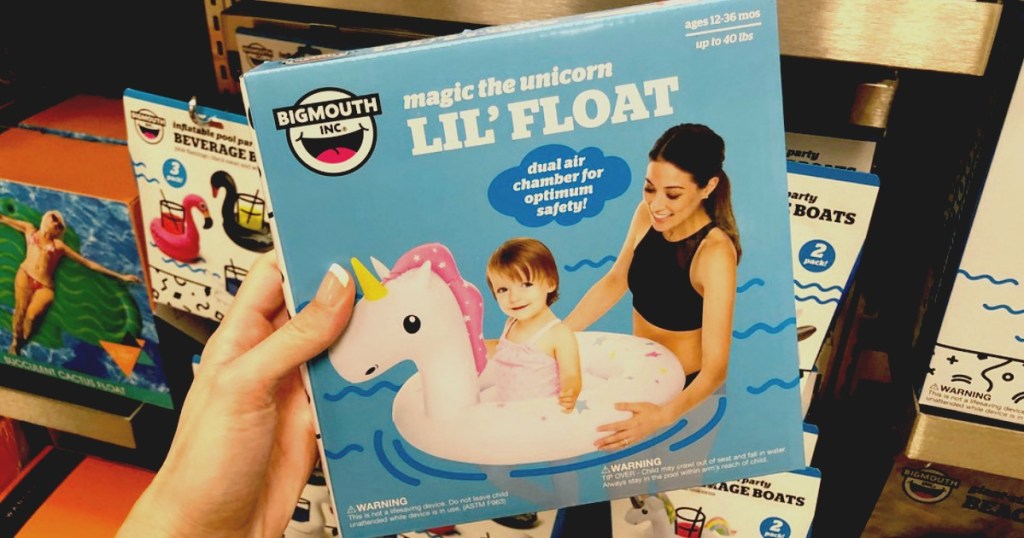 Unicorn Pool Float for little kids being held by a woman in front of other pool floats