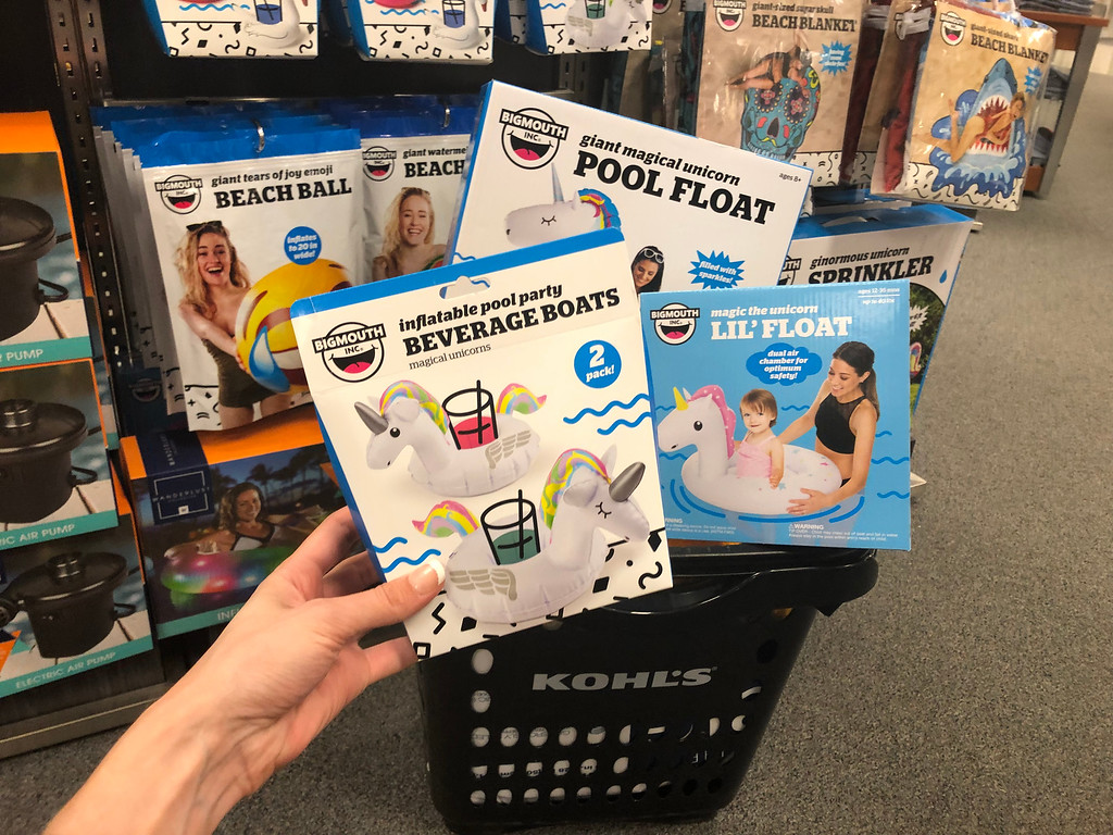 Big Mouth Unicorn Pool Floats one being held by woman's hand and they are in a Kohl's shopping basket