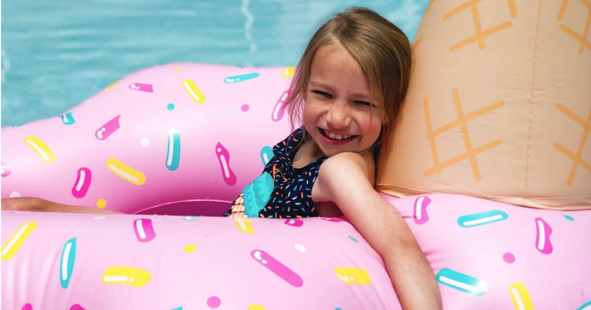 girl laying on ice cream pool float in pool