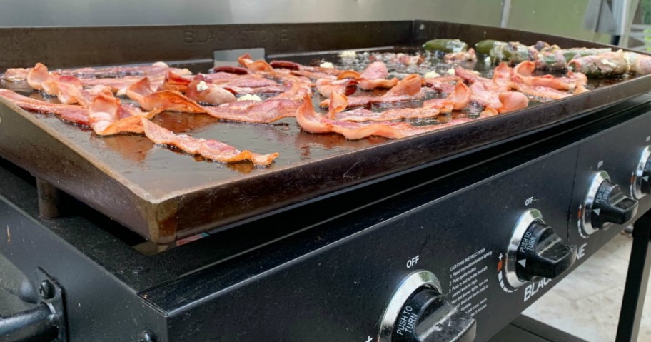 blackstone griddle with bacon cooking on top 