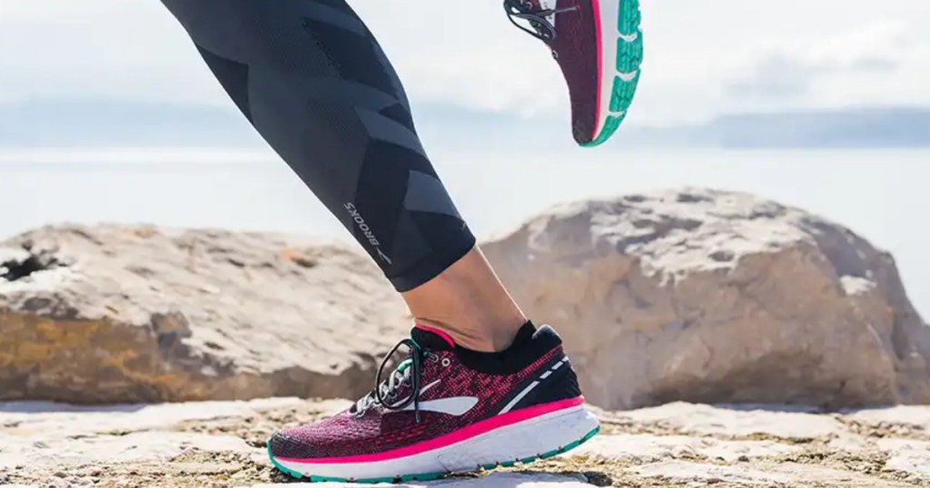 black Brooks Ghost 11 running shoes with pink and teal accents on lady running on trail