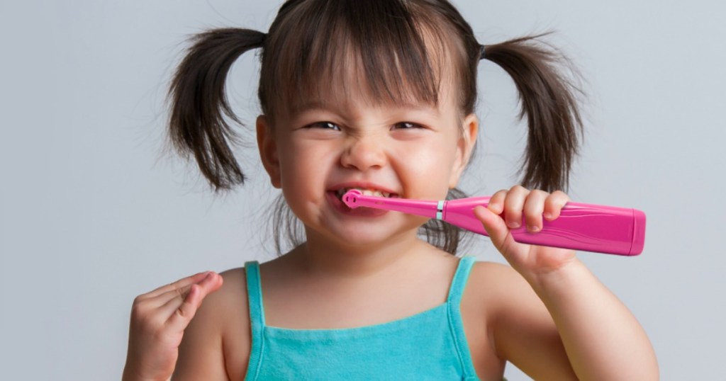 Toddler girl brushing teeth with Brusheez Kids Electric Toothbrush Set