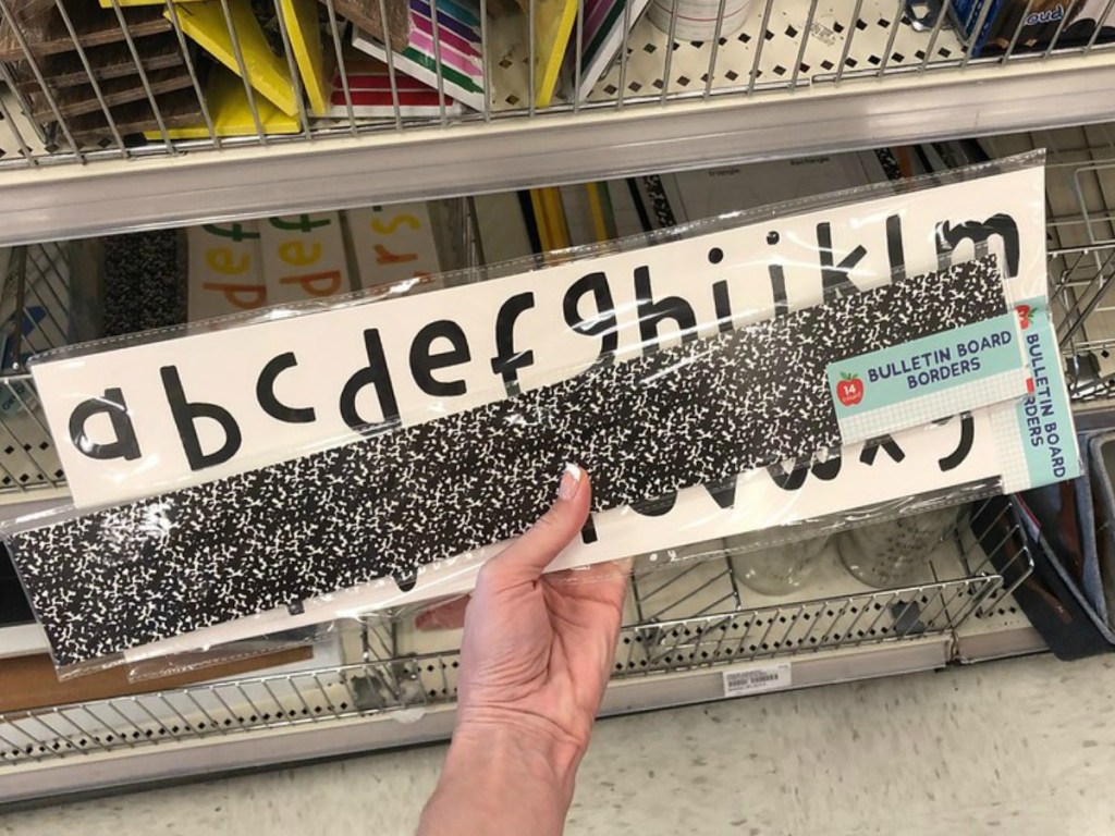 hand holding black letters and borders by store display