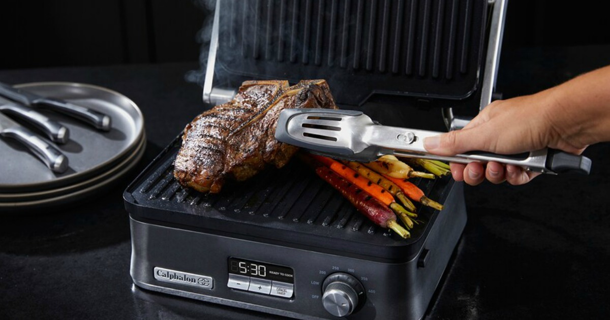 hand with tongs grilling steak on grill