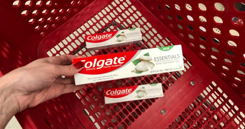 Woman holding Colgate Essentials Toothpaste in box 