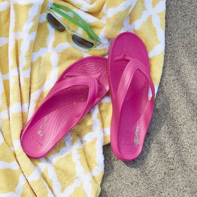 Crocband Flip Flops on a beach towel in the sand