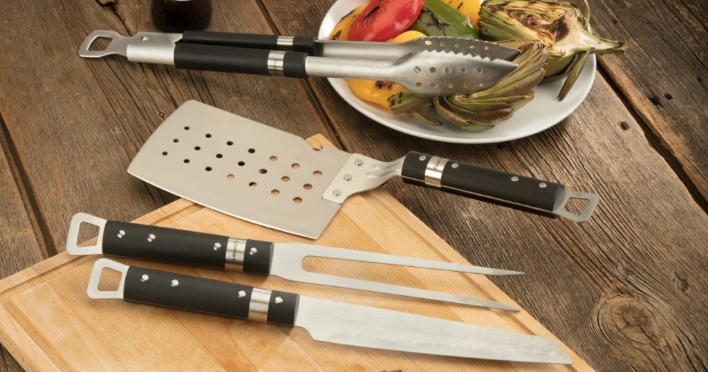 grilling knife, spatula and tongs sitting on cutting board