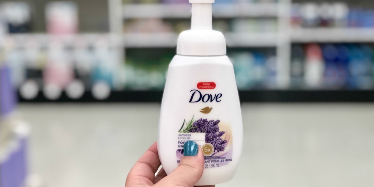 Hand holding Lavendar Dove hand soap in a white bottle in store
