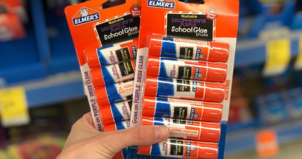 two packages of Elmer's Glue Sticks being held by a woman