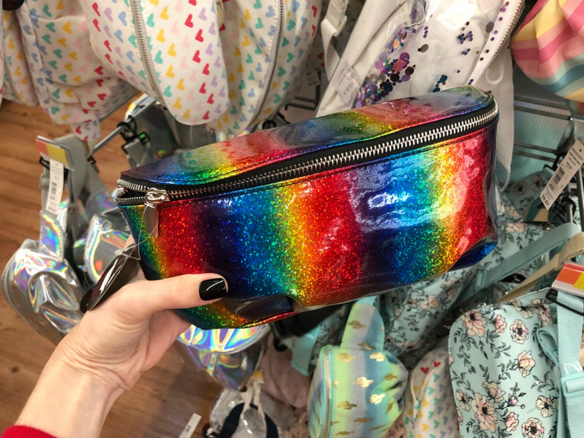 woman holding a rainbow fanny pack at Walmart