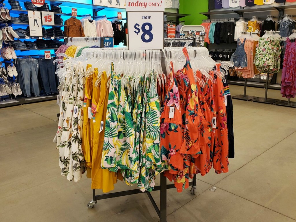Colorfully patterned girl's rompers hanging on circular rack at store