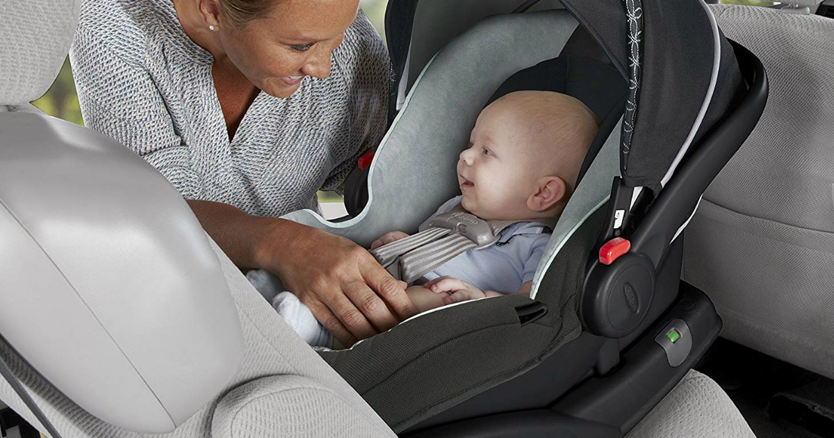 woman buckling baby into car seat