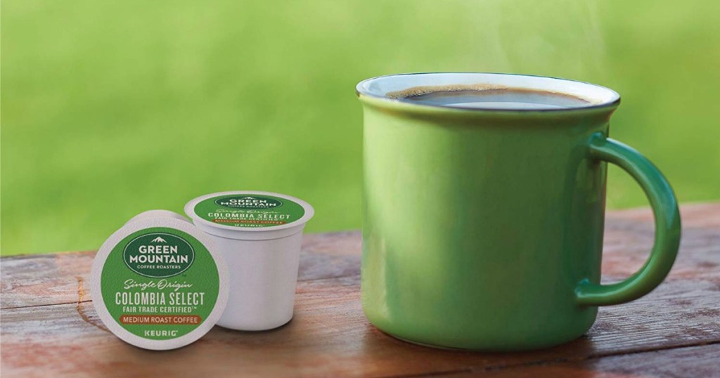 green mug on a table next to Green Mountain coffee K-cups