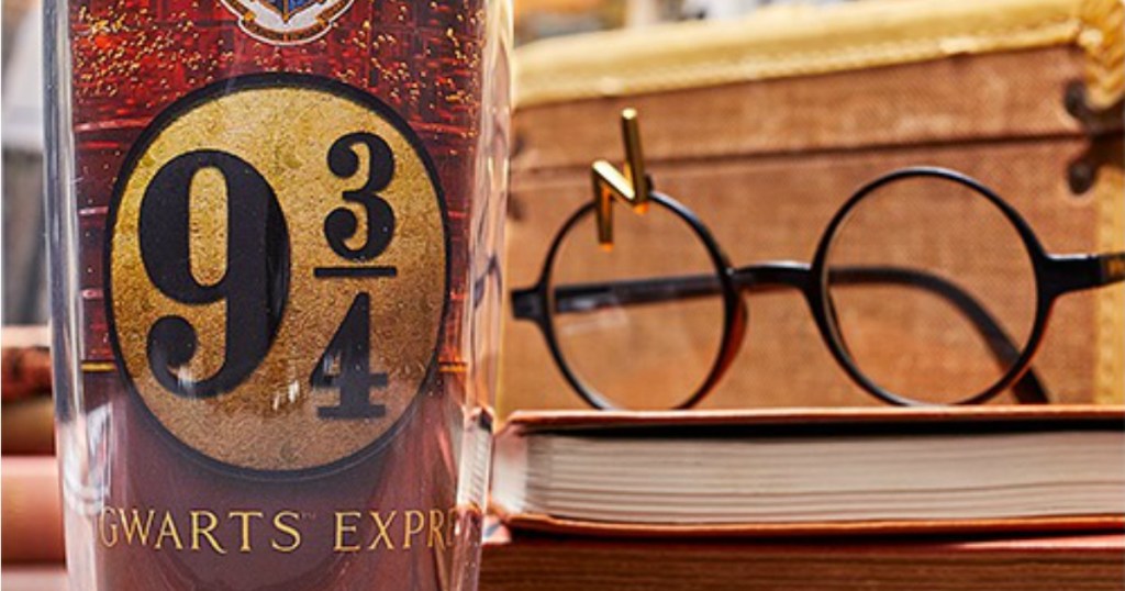Harry Potter tumbler next to lightning bolt scar glasses on book