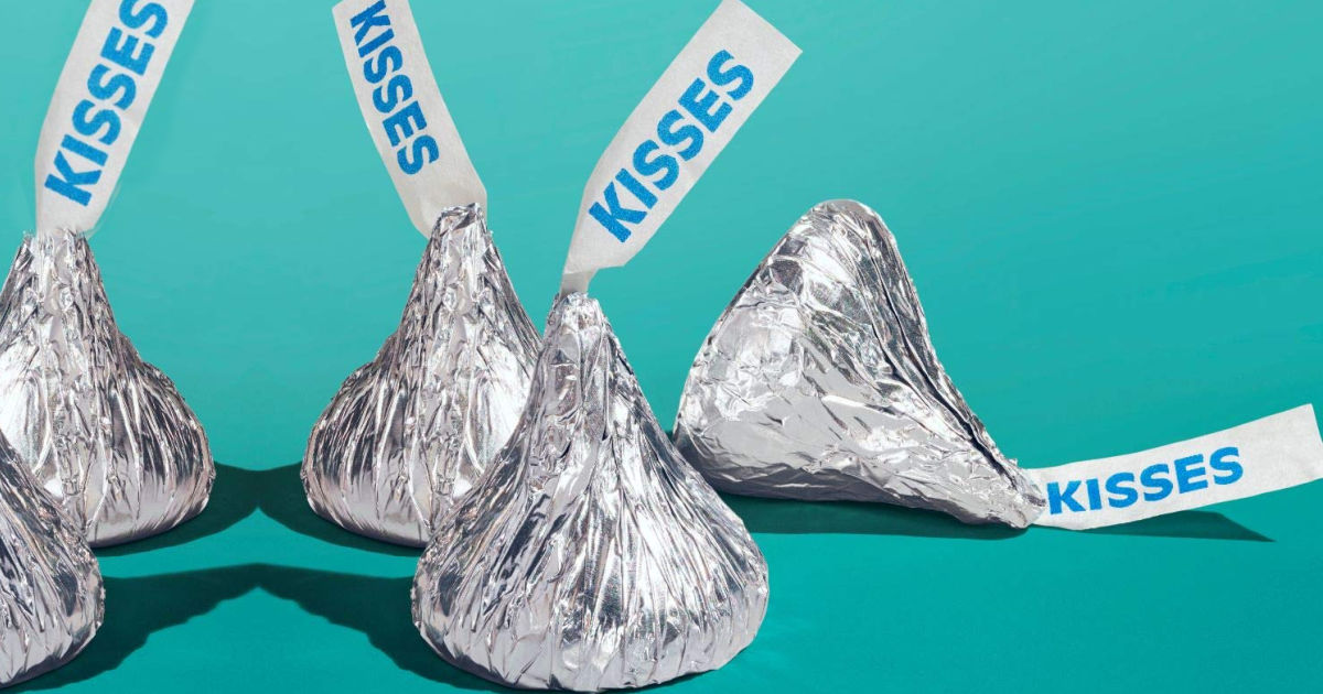 four hershey kisses on teal background