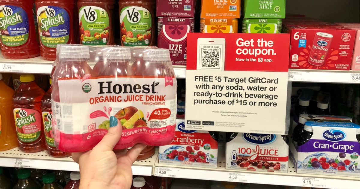 woman holding Honest Kids juice drinks 6-packs in front of sale sign at Target