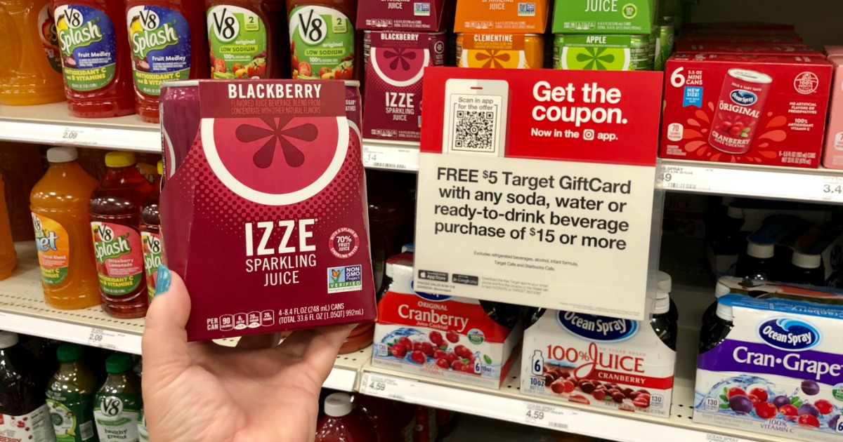 woman holding IZZE sparkling juice in front of Target sale sign